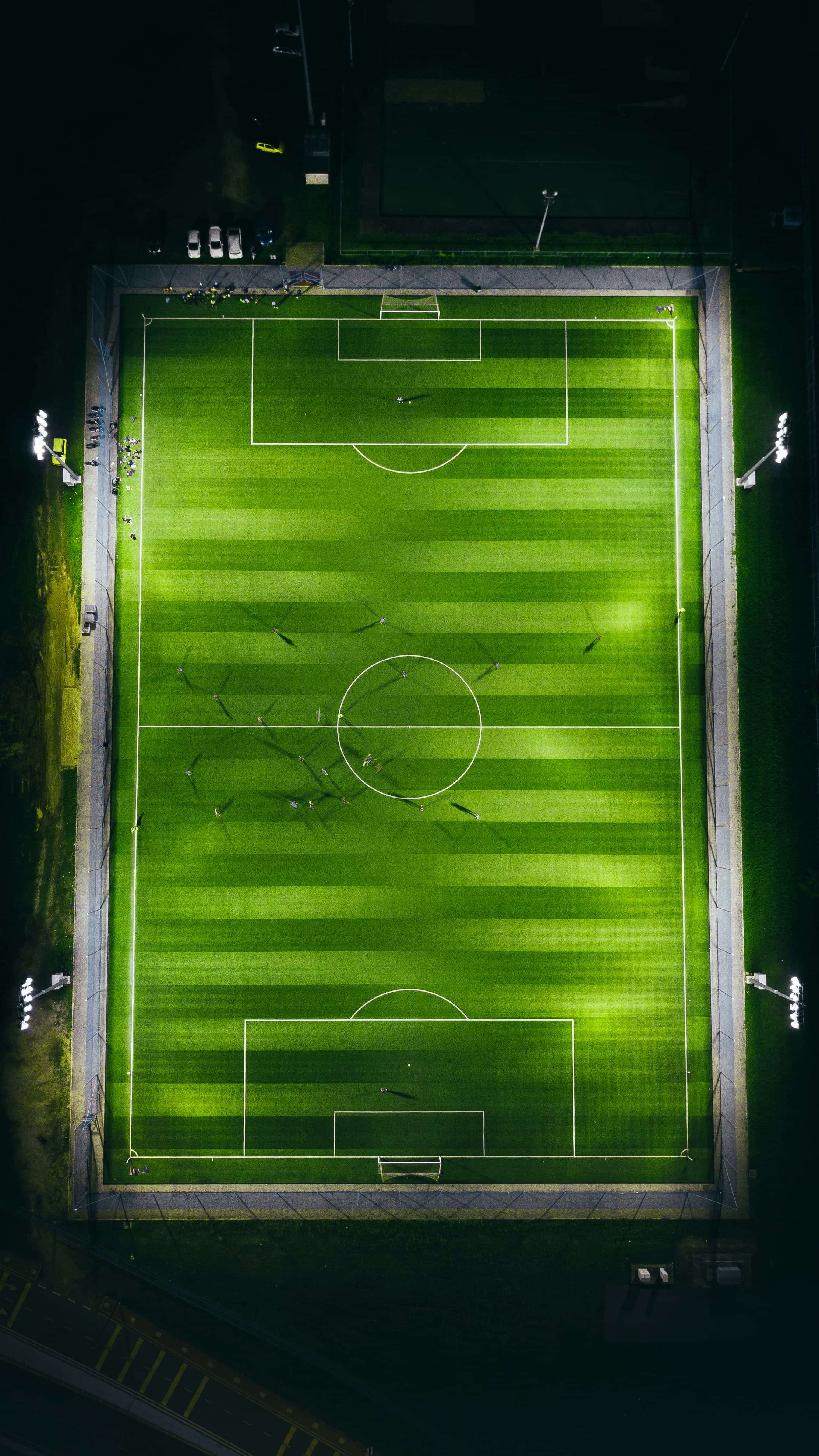 Aerial view of a floodlit football turf at night