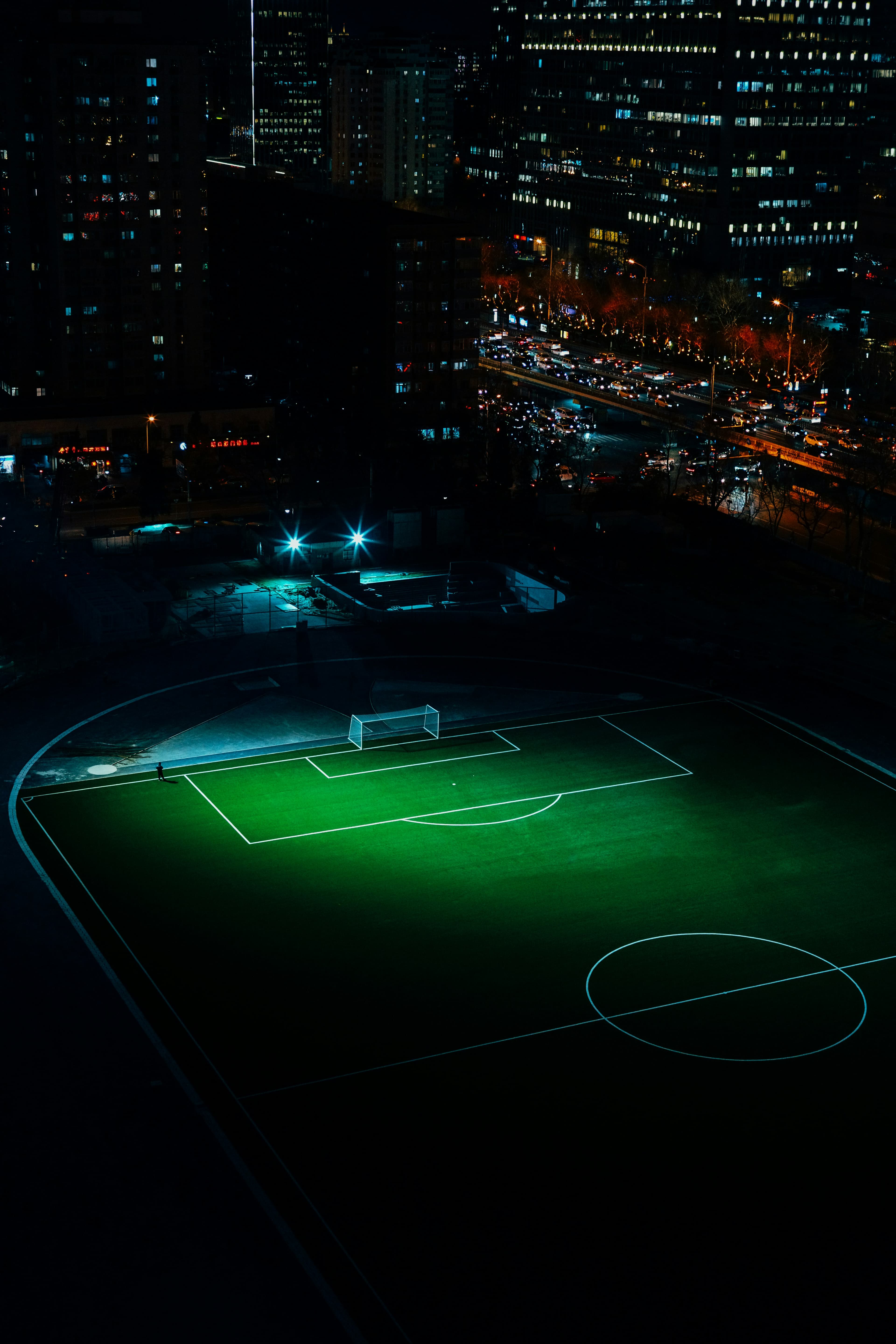 Urban football turf under lights beside the city at night